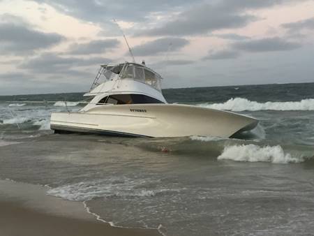 The 54-foot fishing boat Synergy washes up on the beach after capsizing in Oregon Inlet, North Carolina, Sept. 16, 2017. Watchstanders at Coast Guard Sector North Carolina in Wilmington, North Carolina, were alerted at about 5 p.m. that Synergy had capsized and five people were in the water. (U.S. Coast Guard photo, courtesy National Park Service/Released)